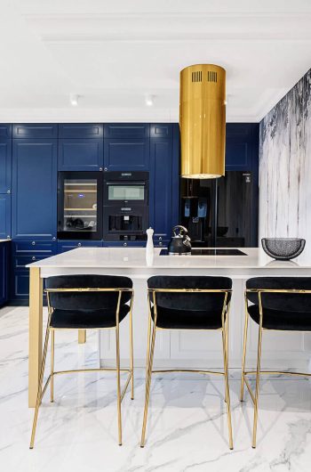 Nowoczesna kuchnia z granatowa zabudową kuchenna. Blat i wyspa wykonane ze spieku kwarcowego Marazzi ''Statuario'' lux.