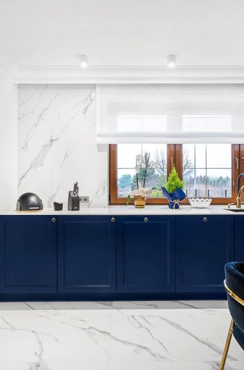 Granatowe meble w kuchni z blatem wykonanym ze speiku kwarcowego Marazzi ''Statuario'' lux.