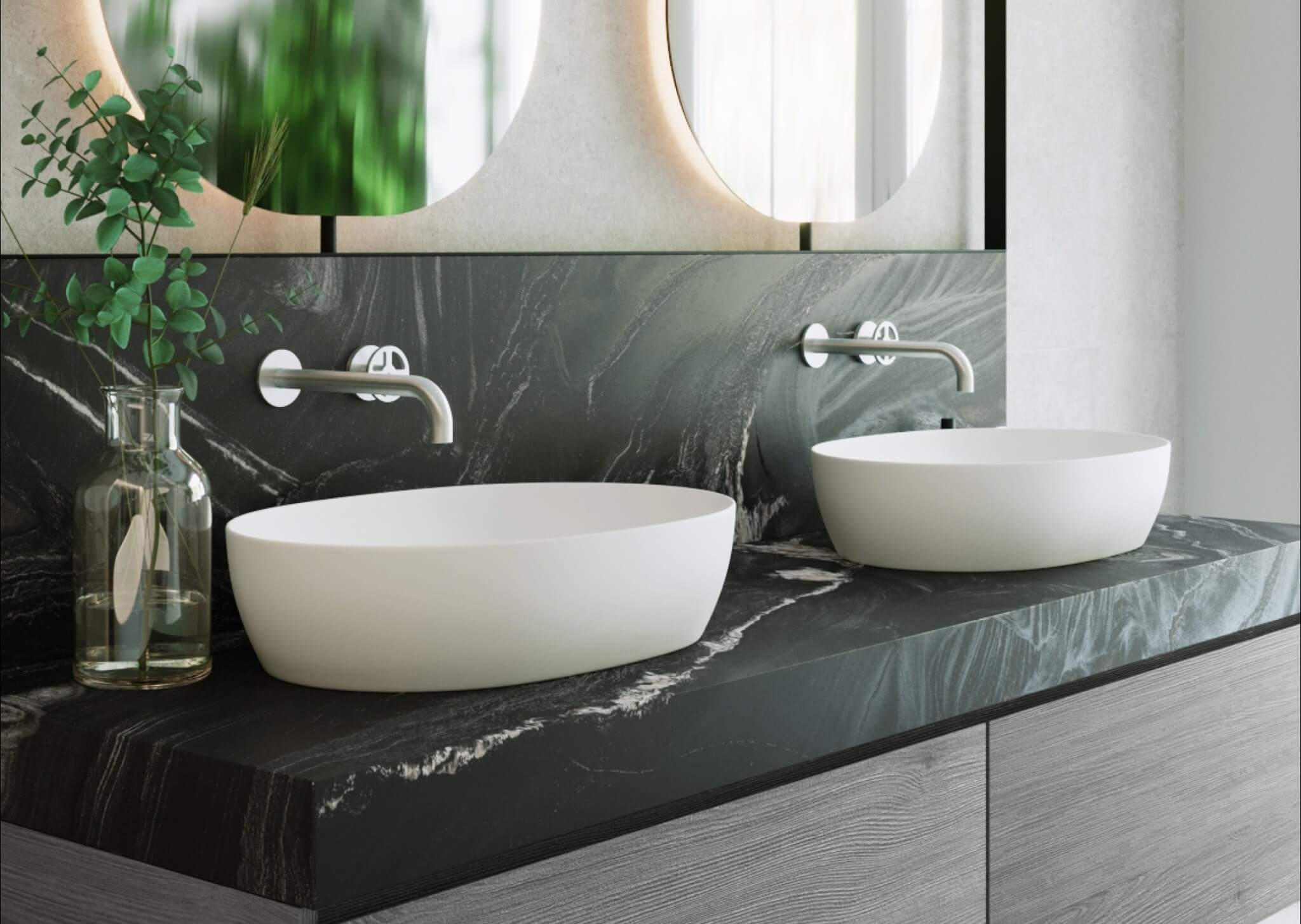 Na zdjęciu widoczna jest elegancka, nowoczesna łazienka wykończona ciemnym kwarcytem o wyrazistym, naturalnym użyleniu. Kamień tworzy zarówno blat, jak i ścienną okładzinę za umywalkami, budując spójną i harmonijną kompozycję. Naturalna struktura kwarcytu pięknie współgra z matową bielą nablatowych umywalek oraz minimalistyczną, chromowaną armaturą ścienną.